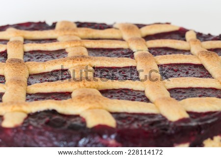Lattice cake with forest berries against white background.
