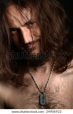 Portrait of young man with long hair and hairy chest