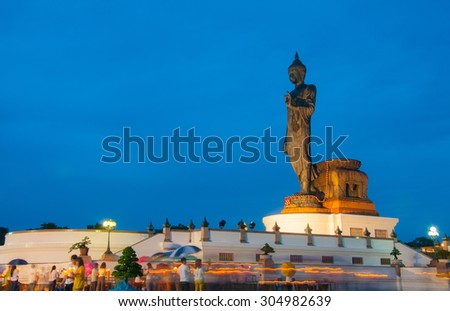 BUDDHA , THAILAND - July 30: High Buddha statue at twilight in Asalha Puja day, the buddhists pray and walk with lighted candles to show respect and faith.