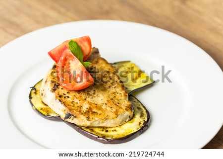 Grilled Eggplant Slice With Pork Chop And Sliced Tomatoes On Plate