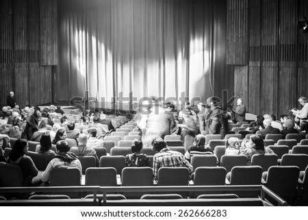 BUCHAREST, ROMANIA - MARCH 22, 2015: Black And White Photo Of People Taking Their Seats In Theater Inside.