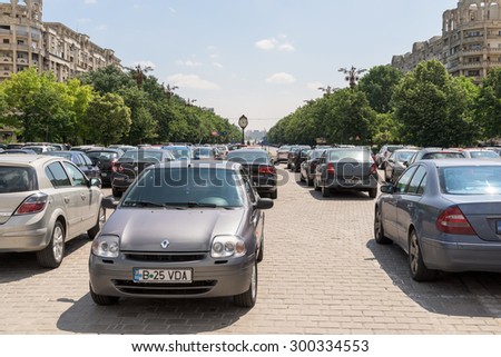 BUCHAREST, ROMANIA - JULY 26, 2015: Cars In Car Parking Lot In Front Of Parliament Palace (Casa Poporului) Or House Of The People In Bucharest.