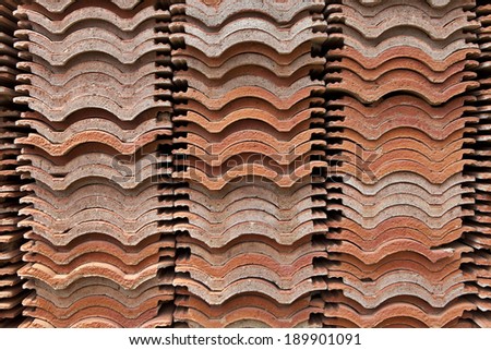 stack of red roof tiles, waving tiles, stock pile, stored, cross section