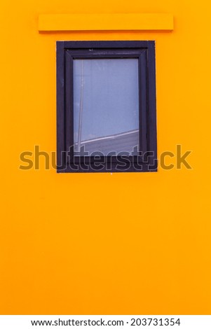 glass windows with black wood frame on bright yellow, colorful wallpaper