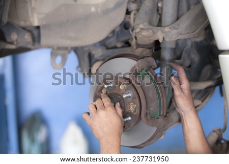 bear hands fixing car wheel hub, disc brake