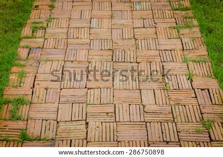 A garden walkway constructed of old bricks and mortar.
