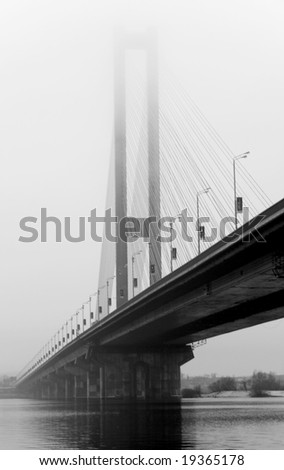 the big river bridge with steel cable support, piers, arch out of fog black white image