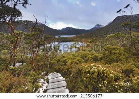 Australia Tasmania Mt Cradle Lake Dove national park overland track to Wombat pool wooden way covered in snow with lakes below and distant Cradle Mountain
