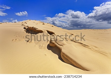 desert sand dunes edge of dry wave after strong wind soil erosion with blue sky and white cloud on bright sunny day