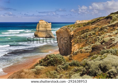 Great Ocean Road in Australia - 1 disconnected Apostle from cliff level with red soil and southern vegetation in foreground on a sunny day