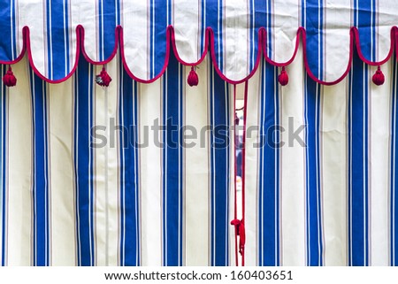 Detail of a blue and white striped tent with red bows