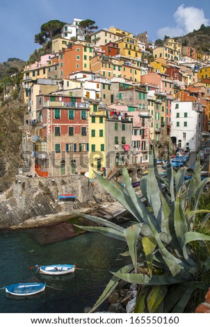 view from the sea of the village of Riomaggiore with the characteristic houses climbing the mountain