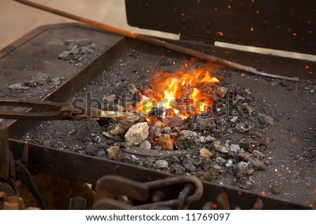 medieval blacksmith method of warming a piece of iron in the fire