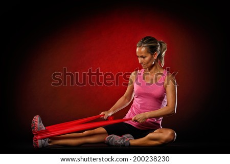 young woman exercise with elastic fitness band in the gym