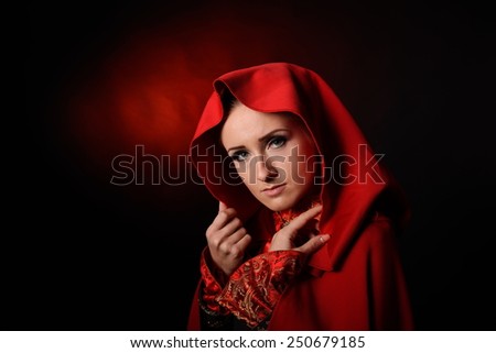 beautiful woman with red cloak posing in studio
