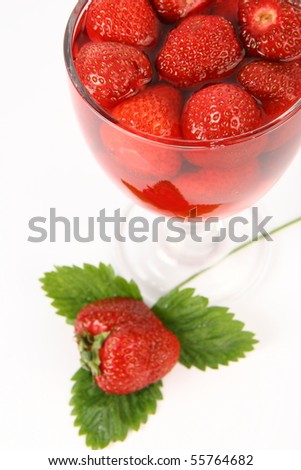 Jelly with strawberries decorated with a strawberry on a leaf in a cup