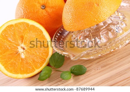 Orange juice being squeezed from fresh fruits with a juicer