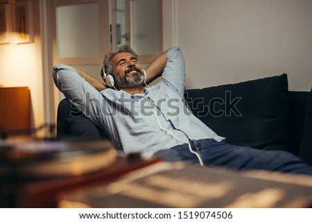 middle aged man listening music at his home