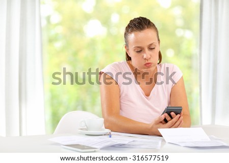 Woman trying to calculate expenses, debt and home economy