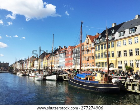Nyhavn in Denmark - Apr 30, 2015: The tourists come to rest, drinking and eating in famous place of Copenhagen by the canalside during the spring