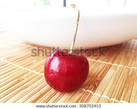 Fresh red cherry on wood plate