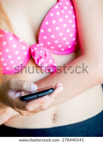 Close up woman use her smart phone in swim suite