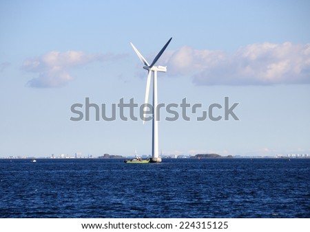 Ocean windmill in rough sea with inspection ship