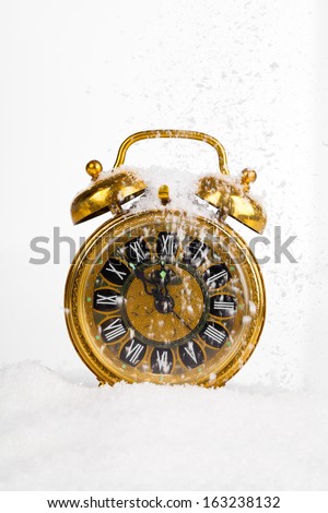 Antique gold clock in the snow. with copy space on a white background