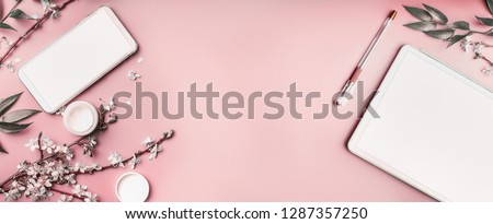 Smartphone and tablet pc mock up on pastel pink desktop background with cosmetic, stationery supples and white blossom branches, top view. Beaut blog and female business concept. Flat lay, banner Photo stock © 