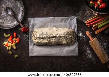Similar – Image, Stock Photo Strawberry rhubarb strudel cake on light mint kitchen table with knife and ingredients. Top view. Homemade seasonal baking