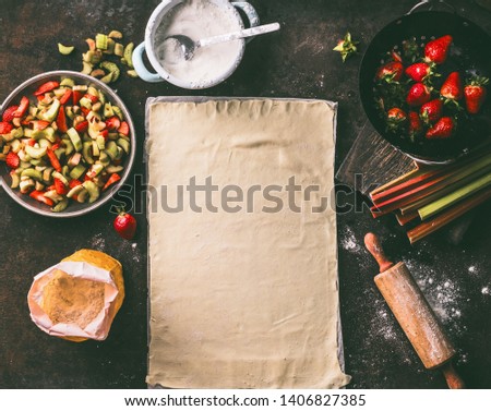 Similar – Image, Stock Photo Strawberry rhubarb strudel cake on light mint kitchen table with knife and ingredients. Top view. Homemade seasonal baking