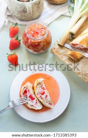 Similar – Image, Stock Photo Strawberry rhubarb strudel cake on light mint kitchen table with knife and ingredients. Top view. Homemade seasonal baking