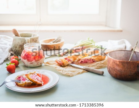 Similar – Image, Stock Photo Strawberry rhubarb strudel cake on light mint kitchen table with knife and ingredients. Top view. Homemade seasonal baking