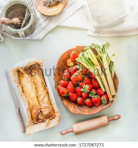 Similar – Image, Stock Photo Strawberry rhubarb strudel cake on light mint kitchen table with knife and ingredients. Top view. Homemade seasonal baking