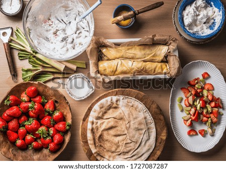 Similar – Image, Stock Photo Strawberry rhubarb strudel cake on light mint kitchen table with knife and ingredients. Top view. Homemade seasonal baking