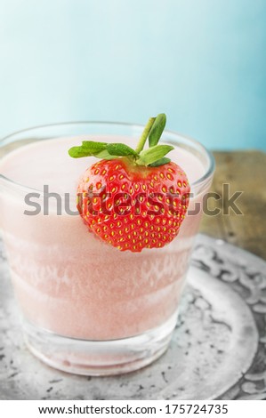 strawberry milk shake in silver plate mit berry on glass