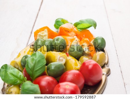 Colorful antipasti mix on white wooden table