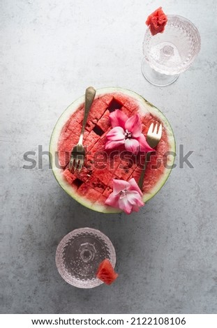 Image, Stock Photo Halved watermelon with golden forks and flowers at grey concrete kitchen table with champagne glasses