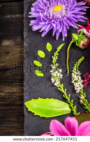 Decoration of autumn flowers on dark table, floral background, top view