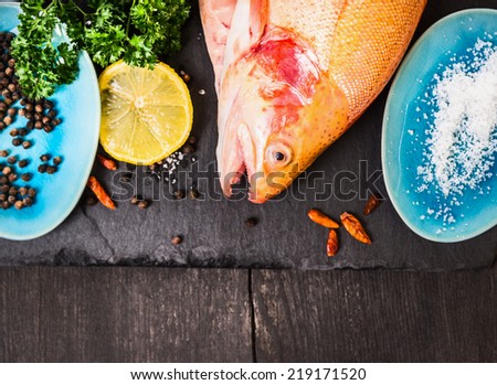 raw rainbow trout with salt,herb and spacy in blue plates on dark wooden table, food background top view