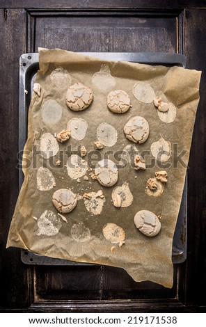 Cookies with cracks  on baking paper and old baking tray, top view