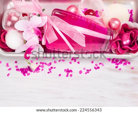 Bath cosmetic set with pink perfume bottle,aroma salt, ribbon and bath flowers, spa background with copy space