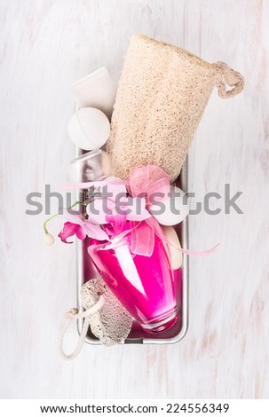 Bathroom spa set  in metal box with  pink bottle bath balls,natural Luffa  sponge and  pumice stone on white wooden background, top view