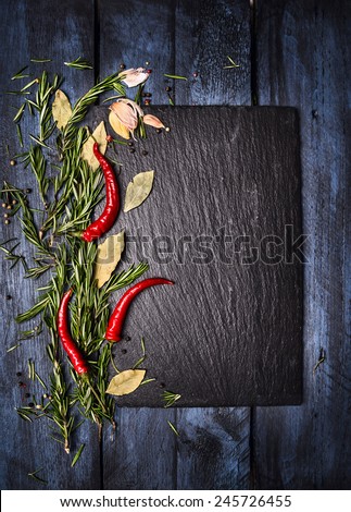 Spices food background with slate on blue wooden table, top view, place for text