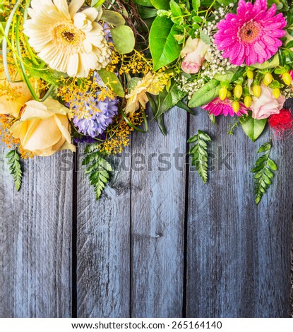 Bunch of flowers on blue wooden background, top view, place for text