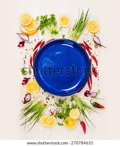 Empty blue plate with fresh seasoning and spices on withe rustic wooden background, top view, place for text