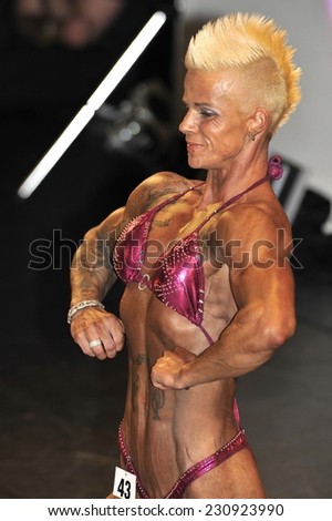 ROOSENDAAL, THE NETHERLANDS - OCTOBER 19, 2014. Female bodybuilding contestant Cindy Limpens showing her chest pose at the bodybuilding and fitness contest of the Walter\'s Open Dutch Championship.