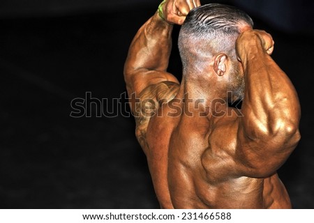 ROOSENDAAL, THE NETHERLANDS - OCTOBER 19, 2014. Male bodybuilder showing the back double biceps pose at the Walter\'s Open Dutch Championship Bodybuilding and Fitness.