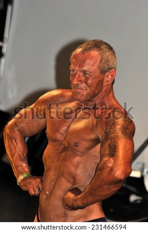 ROOSENDAAL, THE NETHERLANDS - OCTOBER 19, 2014. Male bodybuilder Uwe Abend showing his chest pose  at the Walter's Open Dutch Championship Bodybuilding and Fitness.
