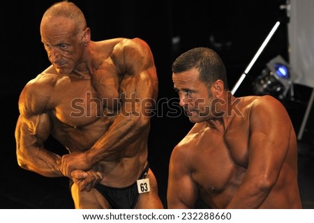 ROOSENDAAL, THE NETHERLANDS - OCTOBER 19, 2014. Male bodybuilders showing their chest pose at the bodybuilding and fitness contest at the Walter's Open Dutch Championship Bodybuilding and Fitness.